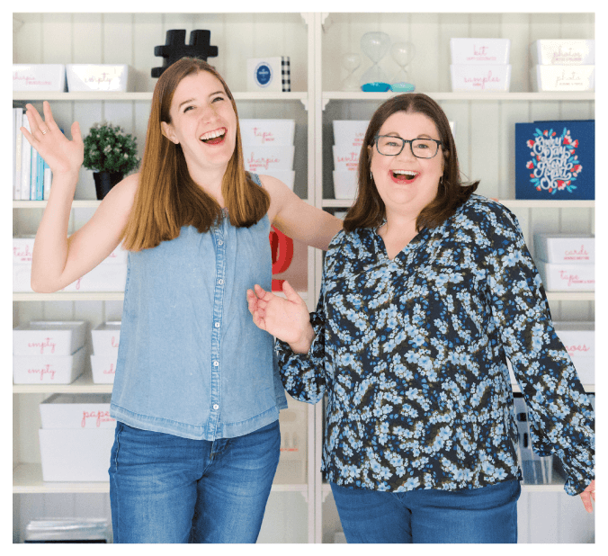Laura Smith and Tasha Lorentz smiling and looking excited in front of organized shelves